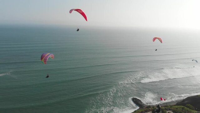 Tourist aerial view of the seawalk of Miraflores, in Lima, Peru. With paragliders, the city cliff and the pacific ocean coast.