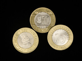 different types of vintage gold and silver bimetallic indian tenrupee coins isolated in a black background