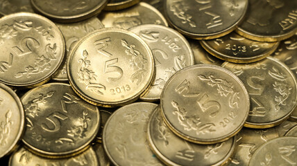 closeup shot of a collection of vintage golden 5 or five rupees in a pile of authentic indian coins