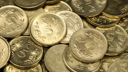 Fotobehang closeup shot of a collection of vintage golden 5 or five rupees in a pile of authentic indian coins © dev