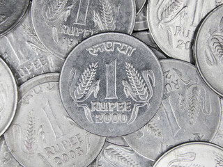 top view of a large collection of shiny old 1 or one rupee vintage silver indian coins in a mixed...