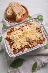 Bolognese and pesto frozen Lasagna on metal Tray for food delivery