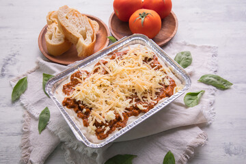Bolognese and pesto frozen Lasagna on metal Tray for food delivery