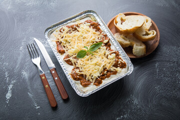 Bolognese and pesto frozen Lasagna on metal Tray for food delivery