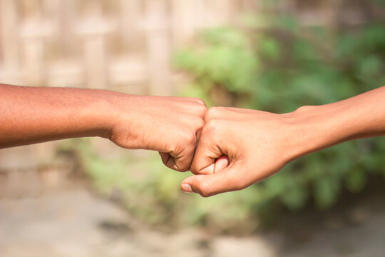 Two human hands joined together in fists and blur background