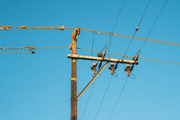 Power electric pole line against blue sky, close-up view