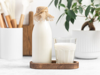 Milk in a glass, bottle of milk, light stylish kitchen
