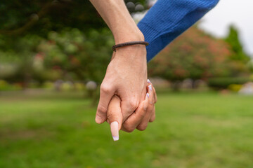 Multi-ethnic couple holding hands in a park