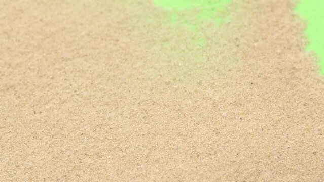 Closeup abstract sand transition blowing over green screen chroma key background