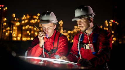 Engineer survey team wear uniform and helmet stand workplace checking blueprint project and radio...