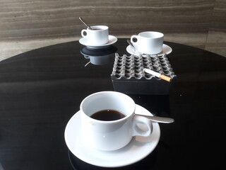 a cigarette on ashtray and a cup of coffee tea at café restaurants