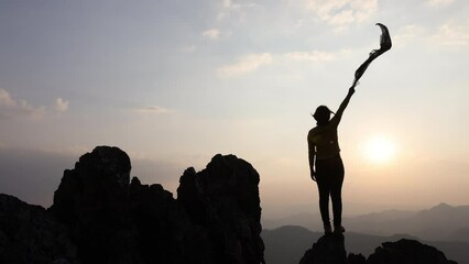 silhouette of free cheering woman hiker open arms at mountain peak, Goals and achievements concept.