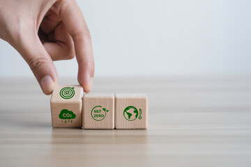 Hand flipping wooden block icon CO2 and target to carbon-neutral for net zero emission. green economy and sustainable environment for the future.Clean Energy and ESG Concept - obrazy, fototapety, plakaty