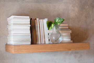 Stack of books on floating wooden bookshelf. Education and knowledge concept. Pile of books to...