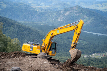 A yellow excavator works in the mountains. Construction of roads and houses in beautiful mountains.