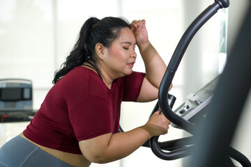 A lady is exercising on a treadmill, she seems focused and determined to achieve her fitness goals.