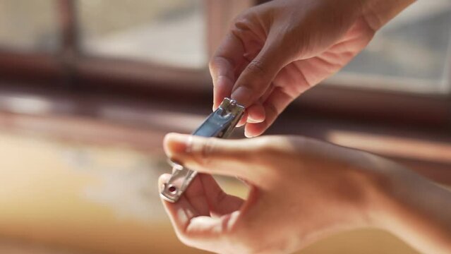 Close up of woman hands finger when cutting nails. Selective focus