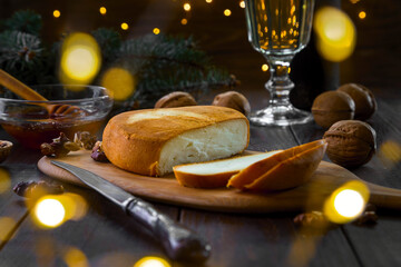 Christmas and New Year theme: Smoked cheese with nuts and a glass of white wine on a wooden background.
