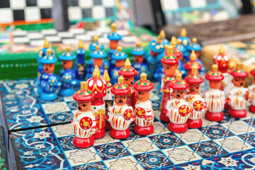 Handmade wooden colorful chess in the form of Uzbek warrior figures. Tourism, souvenir, shopping. Khiva, Uzbekistan