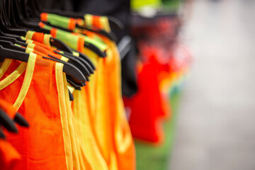 Colorful sportswear for soccer training or shirtfront on hangers in a sports shop. copy space
