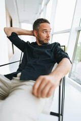 Fototapeta premium Portrait of a man in black shirt posing in photostudio