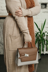 The choice of clothes, the girl's hand in choosing a dress, an outfit on a hanger in the wardrobe in the room, a closet at home. Wardrobe in the house. Clothes for women. Bags. Clothing store.