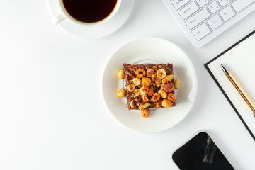 Piece of brownie cake with hazelnuts on white background