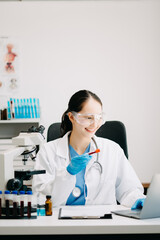 Female scientist researcher conducting an experiment working in chemical laboratory.