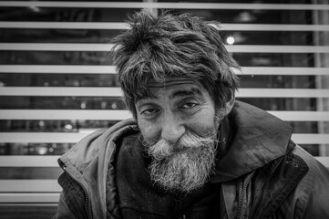 Portrait eines armen obdachlosen Mannes  in Schwarz Weiss - obrazy, fototapety, plakaty