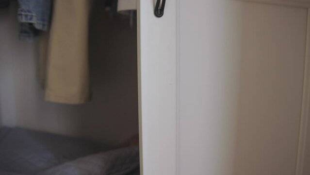 Childhood plays - little Boy playing seek and hide in big clothes cabinet