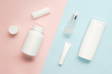Flat lay of cosmetic bottles and tubes on two colored background