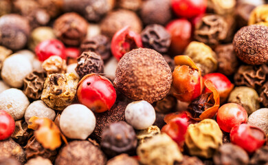 Mix of spices close up. Background of peppercorns of different colors close-up. Colorful red, green, black and sweet peppercorns close up. Spices for food.