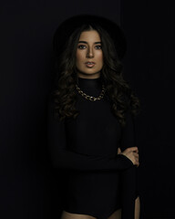 Portrait of an attractive female model in black, solated on a black background.