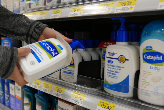 Woman taking Cetaphil gentle skin cleanser inside Walmart store