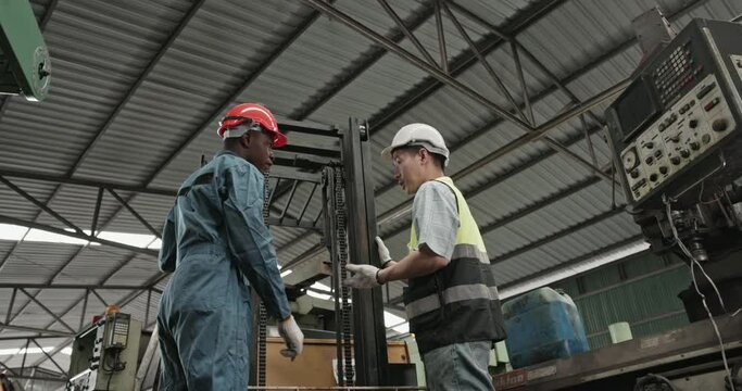 Multi-ethnic engineering team Check mechanical equipment in industrial factory to ensure quality. Technician inspect evaluate maintenance work in construction machine. professional work. Blue collar