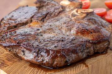 A steak on a cutting board with herbs and spices.Grilled beef tenderloin steak on a wooden board with grilled vegetables. Filet Mignon recipe concept, selective focus
