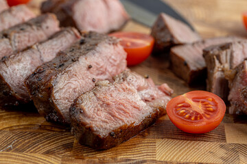 A steak on a cutting board with herbs and spices.Grilled beef tenderloin steak on a wooden board with grilled vegetables. Filet Mignon recipe concept, selective focus