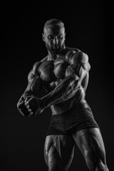 Silhouette of a strong bodybuilder. Confident young fitness athlete with a powerful body and...