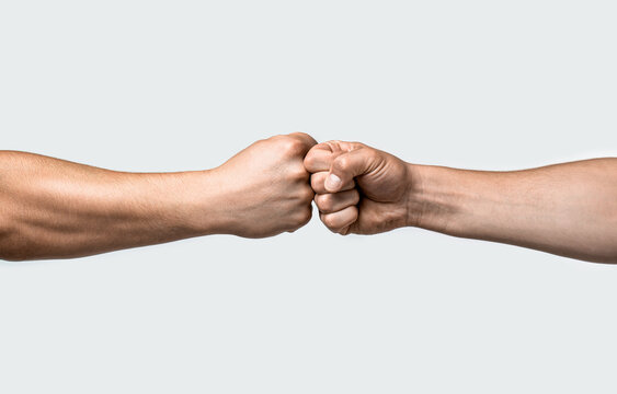 Fist bump. Clash of two fists, vs. Gesture of giving respect or approval. Friends greeting. Teamwork and friendship. Partnership concept. Mans are fist bumping
