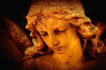 Fototapeta premium Antique statue of gold angel in the sunlight. Religion, faith, death, resurrection, eternity concept. Horizontal image.
