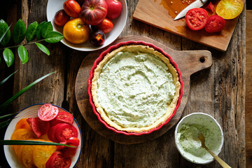 Tart with tomatoes and cream cheese filling with herbs. Side view. Wooden background.  Tart with...