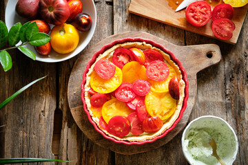 Tart with tomatoes and cream cheese filling with herbs. Side view. Wooden background. 