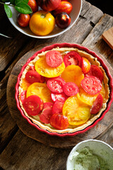Tart with tomatoes and cream cheese filling with herbs. Side view. Wooden background. 