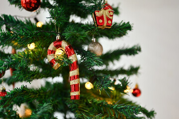 Beautiful Christmas tree branch decorated with candy cane and baubles in living room