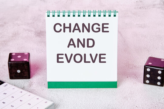 CHANGE AND EVOLVE text on a white notepad sheet next to dice on an abstract background