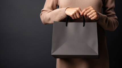 Closeup of woman hand holding shopping bag, online shopping, Black friday sale concept, dark background