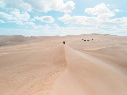 Aerial view of two people standing on a sand dunes in Port Lincoln National Park, South Australia.