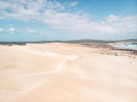 Aerial view of a desert landscape with two people standing on a sand dunes in Port Lincoln National Park , South Australia.
