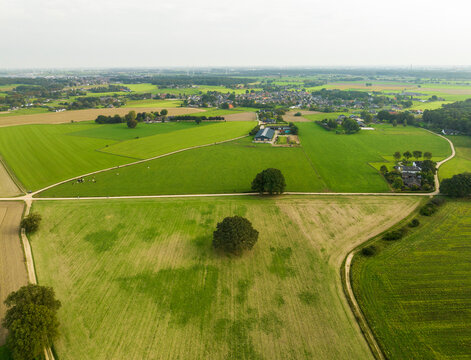 Aerial view of countryside with meadows, cropland and unpaved roads in front of villages Stokkum and 's Heerenberg, Montferland, Gelderland, Netherlands.