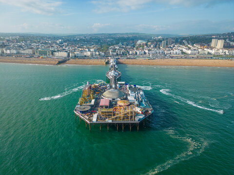 Aerial view of Brighton Palace Pier along the coastline facing the English Channel in Brighton, England, United Kingdom.